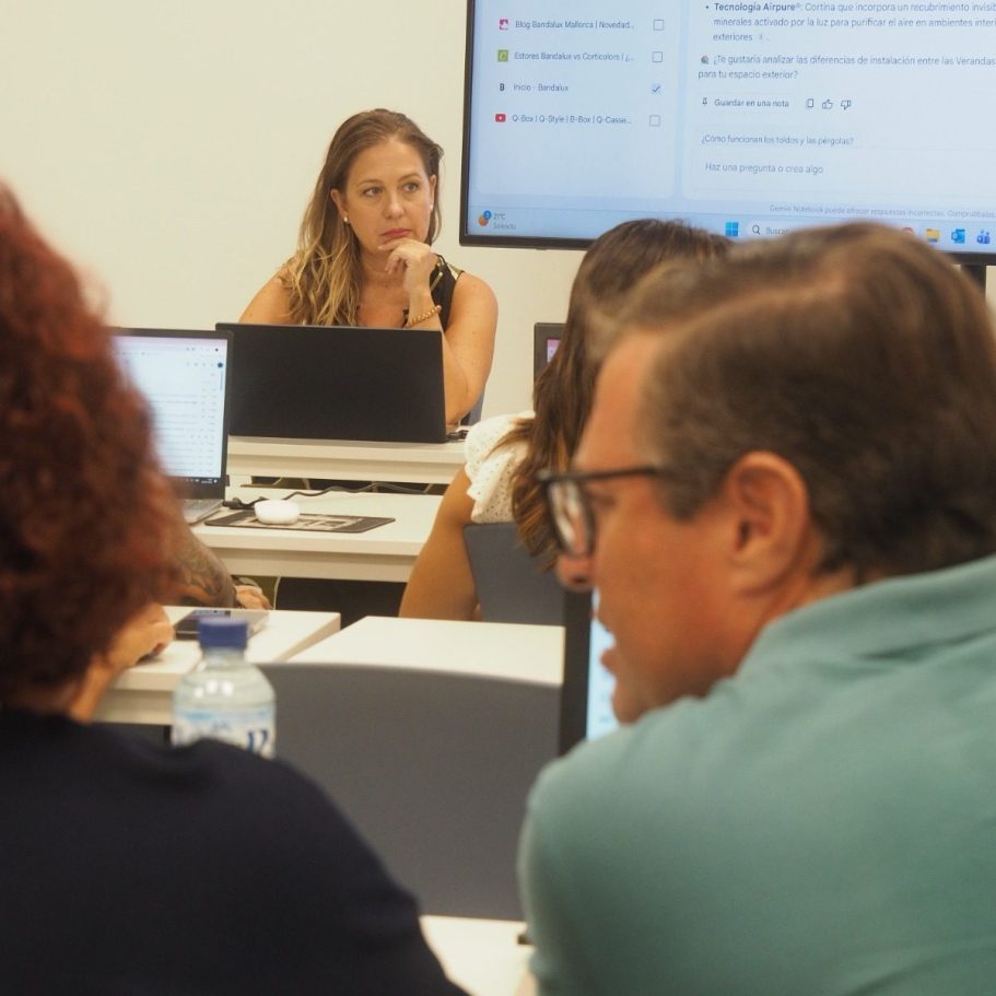Mujer frente a un grupo, levantando la mano mientras los demás participan activamente.